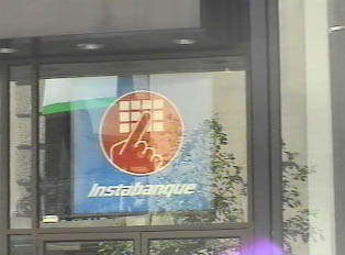 Another bank in downtown with close-up of its ATM sign