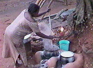 Cooking banku outdoors in a traditional clay stove