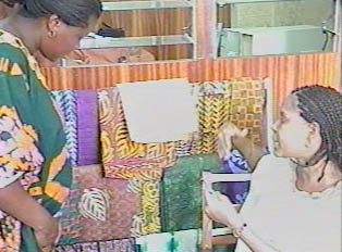 A woman buying fabrics from a tie and dye vendor