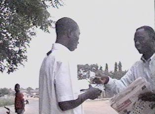 A man buying newspapers from a newspaper seller