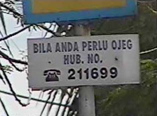 Sign for telephone number to order an ojeg (motor-cycle transport)