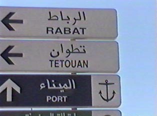 Directional signs on the roadway both in Arabic and Roman script