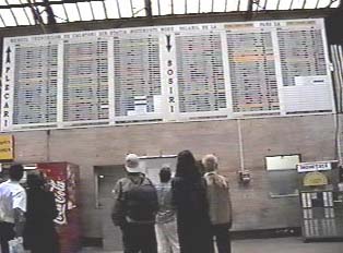 Passengers looking at train arrival and departure schedules