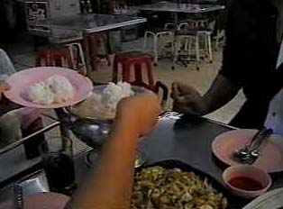 Person serving rice and curry in a restaurant