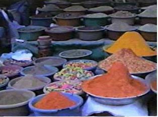 Spices sold by the vendor: ground red chillie, turmeric, garam masala, coriander, cumin, mustard powder, and other spices