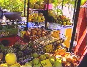 Baskets of fruit at stand. Price signs are not common