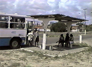 Several people boarding a white bus