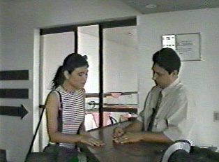 A person talking to a hotel employee at the front desk