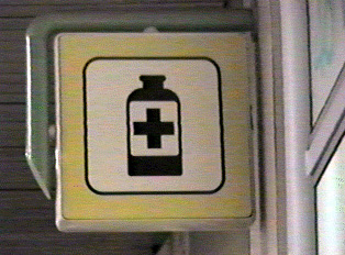 A square, yellow sign depicting a medicine bottle