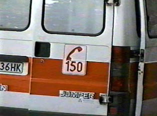 The back of an ambulance, displaying the phone number for health emergencies
