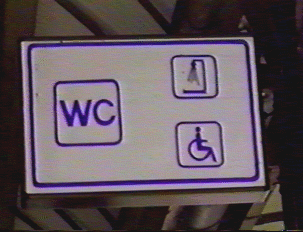 A white and blue restroom sign indicating it is wheelchair-friendly and has showers