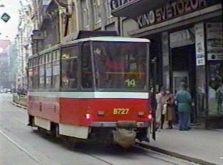A red tram passing through the street
