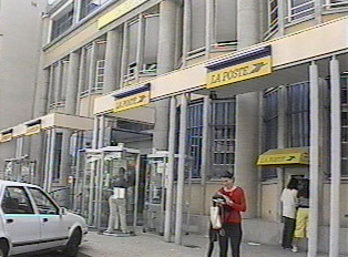 Several people standing outside a post office