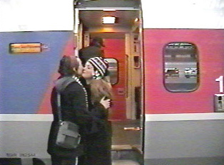 Friends greeting each other in front of a train