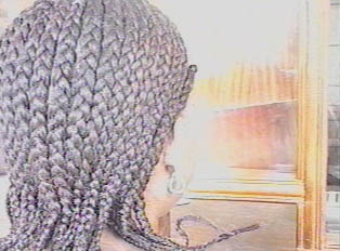 The back of a person's head, showing their braids