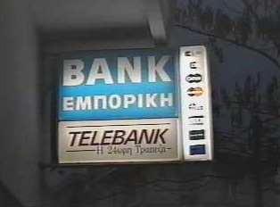 A lit up sign for a bank and ATM, with pictures of the types of credit cards they accept