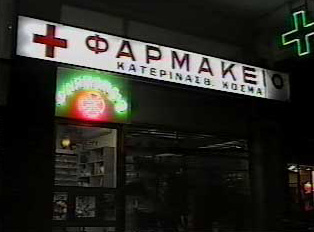 A lit-up pharmacy sign at night