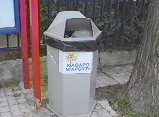 A gray public trash can outside