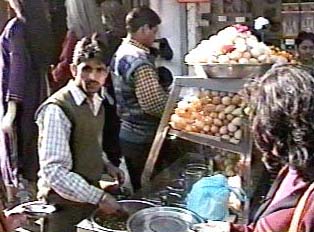Someone purchasing snacks from a roadside street vendor 
