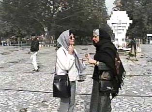 Two modestly-dressed women talking in the street, wearing headscarfs