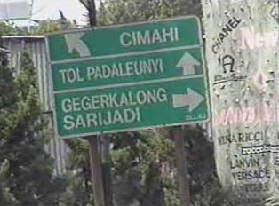 A green sign pointing directions to various locations