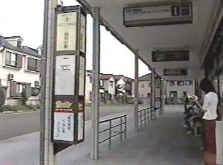A person waiting for a bus at a bus stop