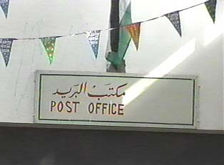 A white sign that reads 'post office' in red letters