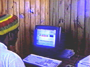 A person sitting at a computer, wearing a colorful hat