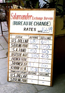 A sign for 'Salamander Money Exchange', displaying conversion rates for different currencies