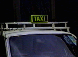 A taxi sign on top of a car