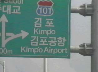 A green sign directing people to an airport