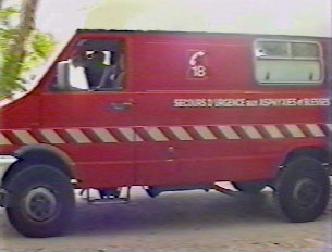 A red ambulance driving down the road