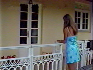 A young woman walking up to the front door of a house