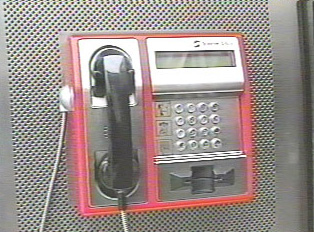 A red and silver public telephone