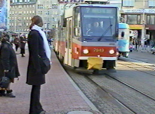 A tram pulling up to a stop