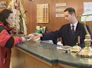 A person reserving a room at a hotel counter