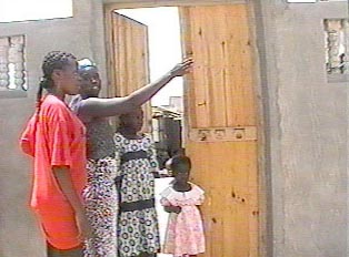 A person giving directions at the door of a home