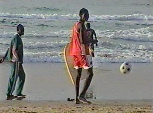 People playing soccer at the beach