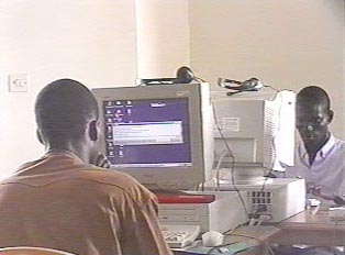 Two people on computers at a cyber cafe