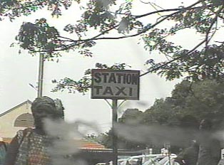A sign on the side of the road that reads "taxi station"