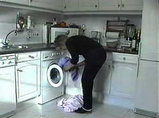 A person putting clothes in the washing machine