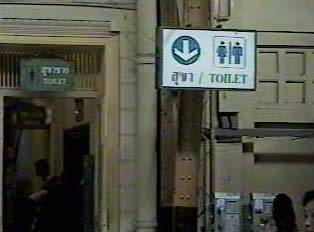 A white sign indicating a public restroom