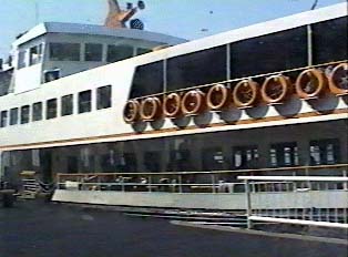 A view of a white ferry, with life preservers along the side